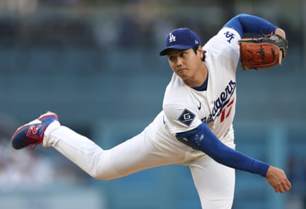 Shohei Ohtani mid-pitch delivery in a white Dodgers uniform.