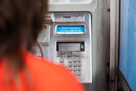 A view of an old payphone dialpad over the shoulder of Caitlin Cassidy