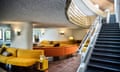 A staircase and yellow seating in the public area of a hotel.