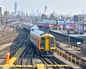 Urban landscape train tracks & distant London skyline with South West Trains passenger service returns to depot at Clapham Junction train station UKG2P77E Urban landscape train tracks & distant London skyline with South West Trains passenger service returns to depot at Clapham Junction train station UK