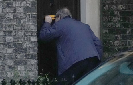 An unidentified man looks through the letter box of the Wiltsire house.