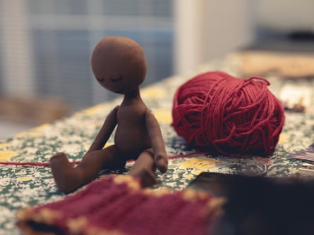 a doll and some red yarn