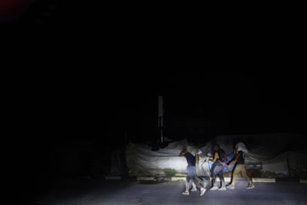 A group of Palestinians walking and carrying parcels in the dark
