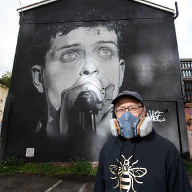 Street artist Akse, in front of his mural of Ian Curtis in 2020.