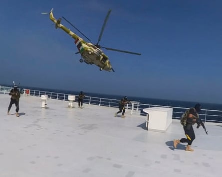 Houthi forces boarding a ship.