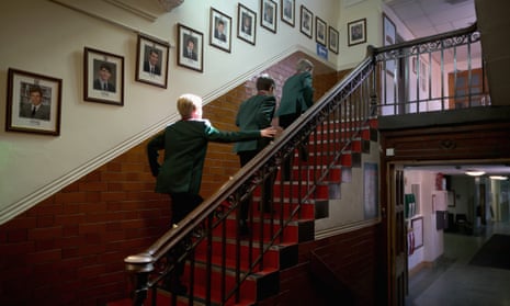 Pupils make their way to class past photographs of former headboys at Altrincham Grammar School for Boys in Altrincham, England. 