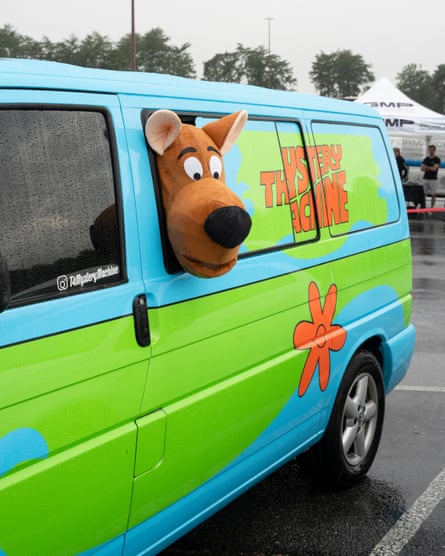 A plush Scooby-Doo head pokes out of a van window painted like the Mystery Machine