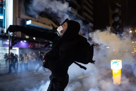 A protester reacts after police fire tear gas to disperse bystanders in a protest in Hong Kong on 25 December 2019.