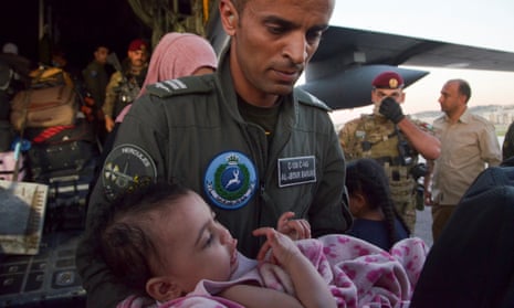 A member of the Royal Jordanian air force carries a child as Jordanian citizens and other nationals who were evacuated from Sudan, arrive at Marka Military Airport, in Amman, Jordan 25 April 2023.