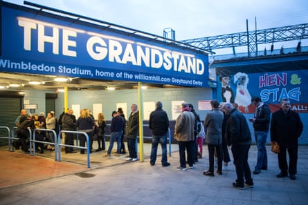 Racegoers queue outside Wimbledon Stadium before it opens for its penultimate meeting.