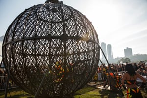 Spectators gather around the Globe of Death motorcycle stunt show.