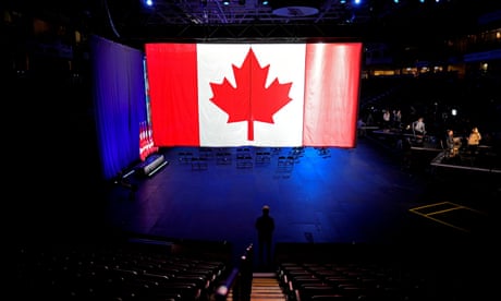 FILE PHOTO: A man stands under a giant Canadian flag before the Conservative election party, in Oshawa,<br>FILE PHOTO: A man stands under a giant Canadian flag before the Conservative election party at the Conservative party headquaters, in Oshawa, Ontario, Canada September 20, 2021. REUTERS/Mark Blinch/File Photo