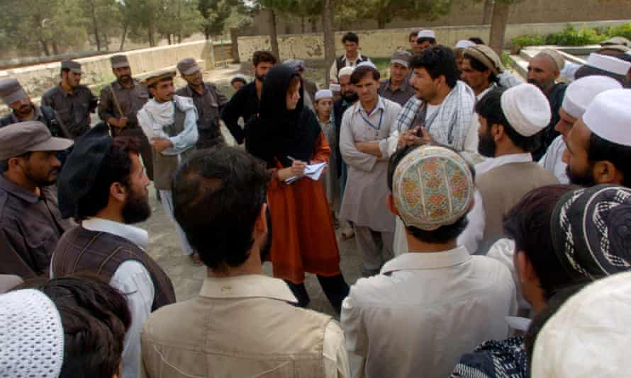 Barker interviewing a group of men near where a US bomb had struck in 2001.