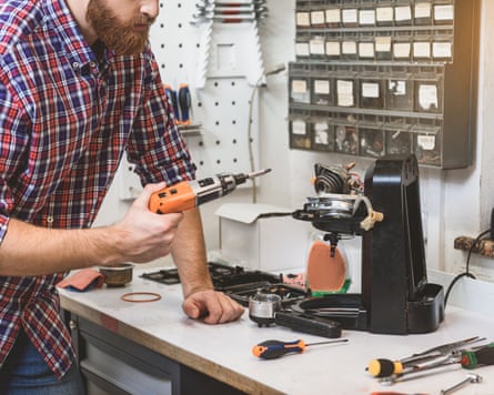 A man fixes a coffee machine on a workbench