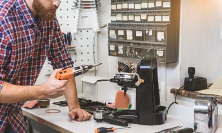 A man fixes a coffee machine on a workbench