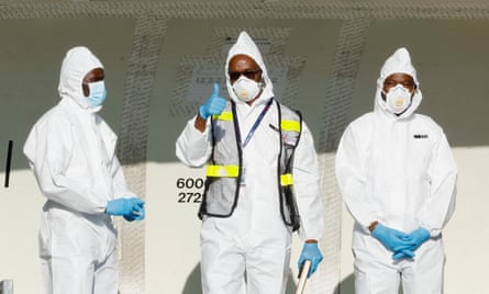 ECHO crew give the photographer a thumbs-up while dressed in plain white PPE suits and face masks