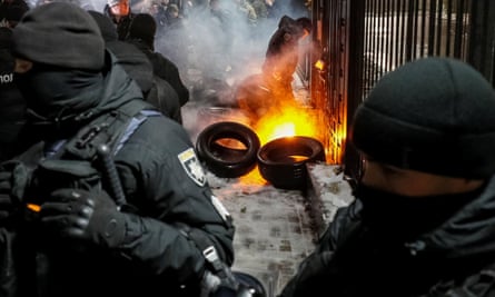 A National Guard officer extinguishes a torch thrown during a rally in front of the Russian embassy in Kiev.