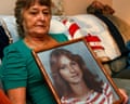a mother holds a photo of her daughter