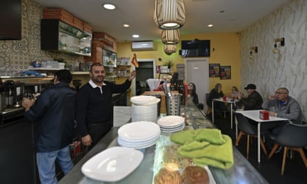 A bar worker in Ceuta waves a Spain flag ahead of the World Cup last-16 match against Morocco