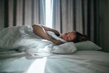 Woman sleeping well in a room with daylight coming through the curtains.