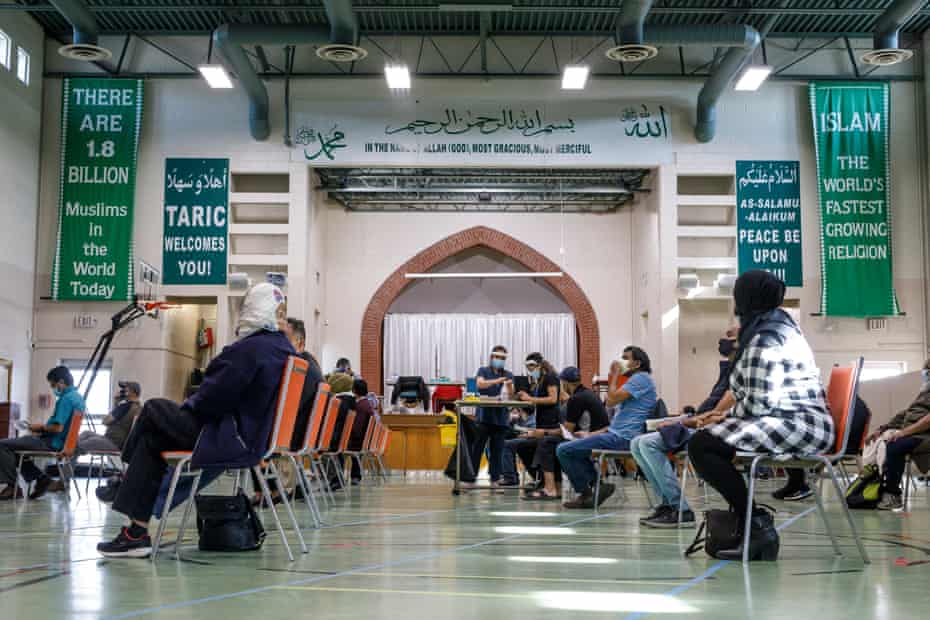 People wait as healthcare workers from Humber River hospital administer Moderna vaccines at the Toronto and Region Islamic Centre congregation.