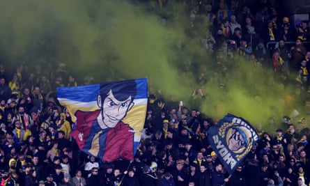 Union Saint-Gilloise fans show their support with flares and flags at Lotto Park in Brussels.