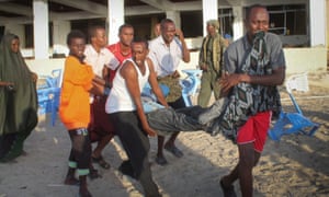 People carry an injured man after Somali security forces took control over of the restaurant and ended the siege in Mogadishu where gunmen exploded car bombs and opened fire on people on Thursday.