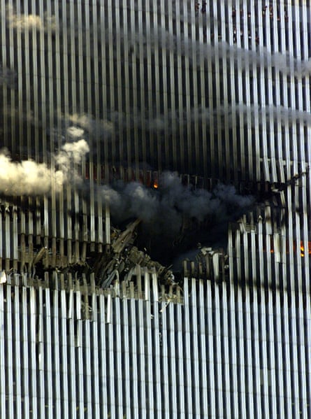 smoke billows from a hole in a building where a plane crashed into it
