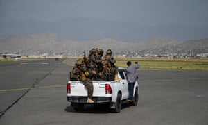 Members of the Taliban Badri 313 military unit ride a vehicle on the runway of the airport in Kabul on August 31.