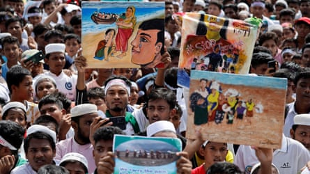 South Asian men and boys holding placards with slogans such as ‘stop genocide’ and paintings of refugees