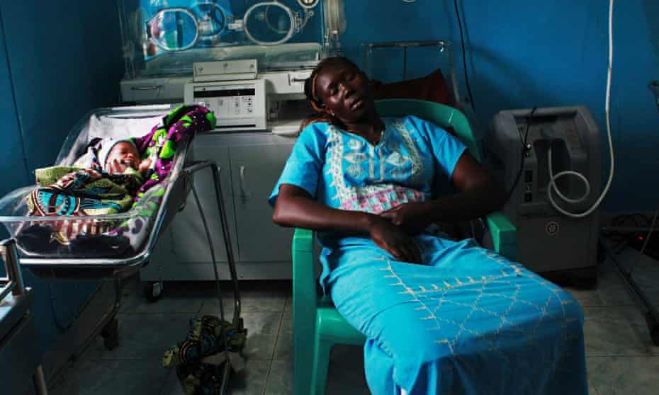 A woman sleeps next to her newborn baby in a nursery in the Juba Teaching Hospital, South Sudan