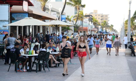 People are seen walking on the Hollywood Beach Boardwalk in Florida, USA on 26 June, 2020 as Florida reports another record spike in coronavirus cases.