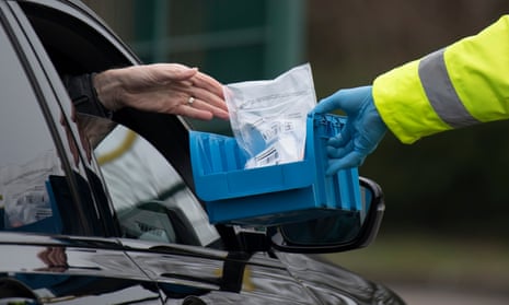 A coronavirus test is handed through a car window in Stoke Gifford, Gloucestershire