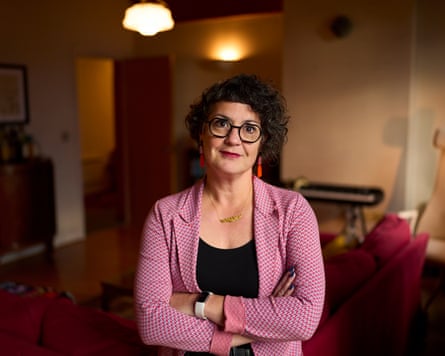 Laura Murphy in a sitting room with arms folded in a pink jacket