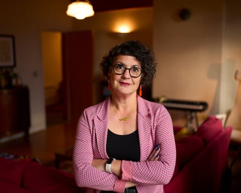 Laura Murphy in a sitting room with arms folded in a pink jacket