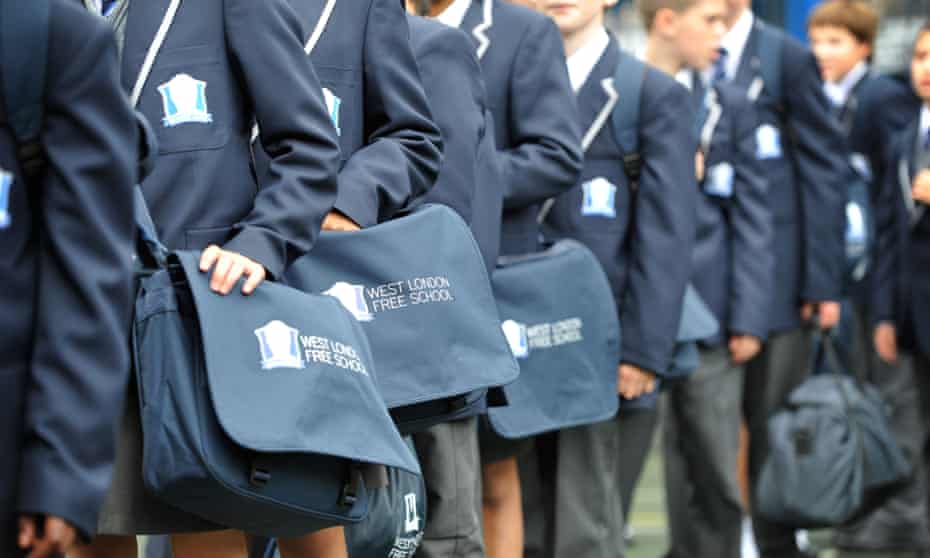 Pupils line up in the playground of the West London free school. Pic shows uniforms and bags but not faces