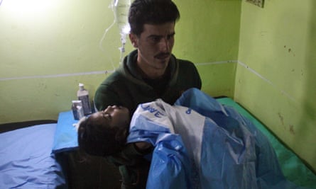 An unconscious Syrian child is carried at a hospital in Khan Sheikhun.