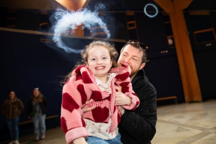 Amelia, aged six, smiles as a smoke ring pops above her head
