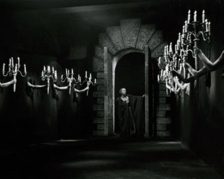 Belle in dark corridor with arms holding candelabras