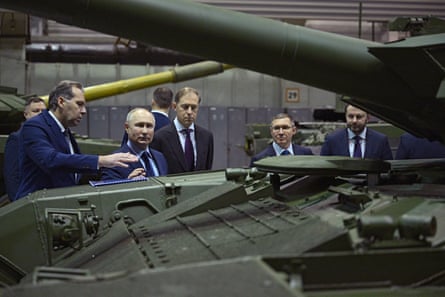 Vladimir Putin is shown a tank at a factory in Russia