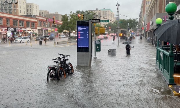 A person wades through the flood water near the 157th St metro station in New York City on Thursday.
