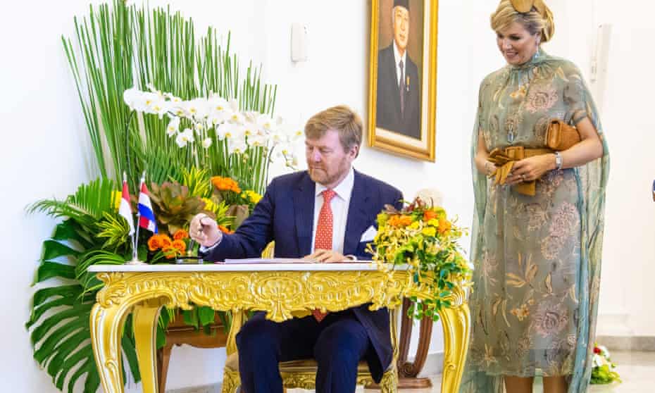 King Willem-Alexander seated at a desk and Queen Maxima looking on at the president’s Bogor Palace