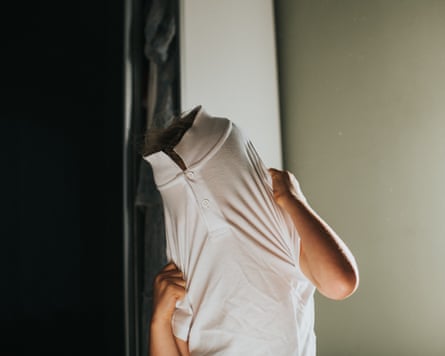 Little boy dressing himself, stuck inside a buttoned polo shirt.