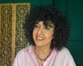 A smiling middle-aged Persian woman in a blouse and without a hijab
