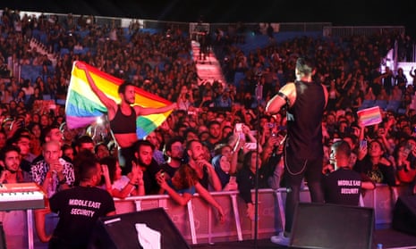 A fan holds a rainbow flag at a performance by Mashrou’ Leila in Lebanon.