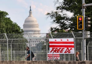 A Washington, DC, flag reading Free DC hangs from an overpass with a view of the US Capitol.
