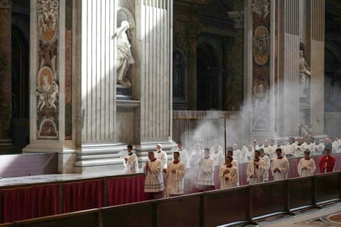 Members of the clergy walk in a procession inside St Peter's basilica with incense as the Pope's coffin is transported from the chapel of Santa Marta to St Peter's Basilica, following the Pope's death.