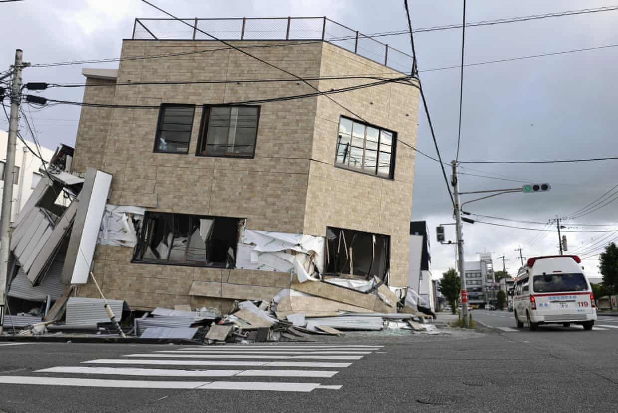 An ambulance passes by a collapsed building in Yatsushiro, Kumamoto prefecture, on Wednesday.
