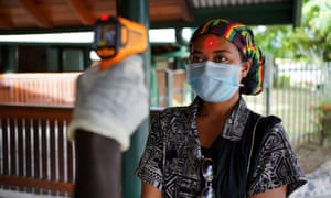 A woman’s temperature is checked in Kokopo, East New Britain province, Papua New Guinea.