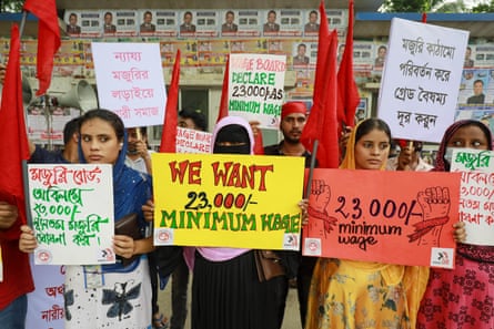 Women hold placards calling for a minimum wage of 23,000 taka